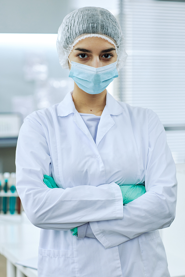 Female scientist standing in laboratory with arms crossed